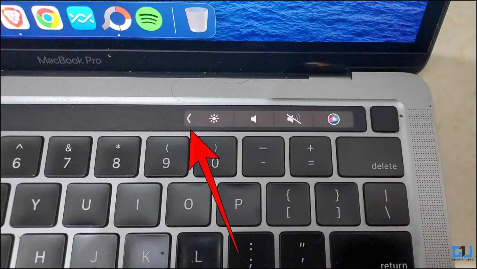 MacBook 터치바에서 왼쪽을 향한 화살표를 탭합니다.